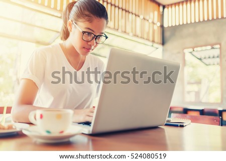 Business entrepreneur asian girl working online on laptop in cafe.