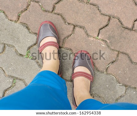 Feet are walking on the street in the park