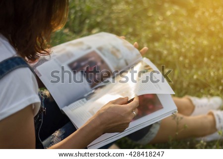 Woman reading a magazine in garden.