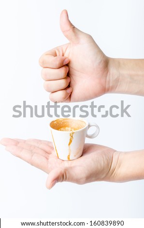 Like hand sign behind a white espresso coffee cup in another hand. I like, love, good espresso coffee concept