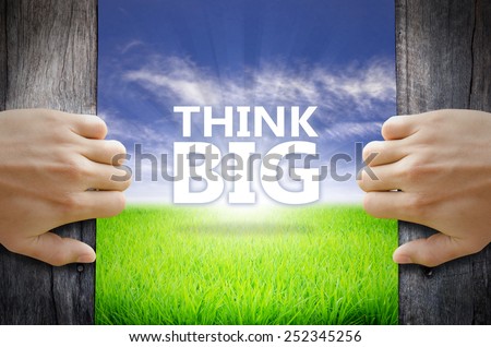 Thing Big motivational quotes. Hand opening an old wooden door and found a texts floating over green field and bright blue Sky Sunrise.