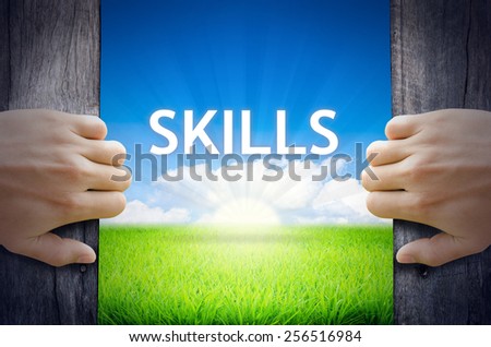 Skills. Hand opening an old wooden door and found Skills word floating over green field and bright blue Sky Sunrise.