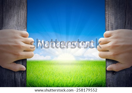 Management. Hand opening an old wooden door and found Management word floating over green field and bright blue Sky Sunrise.