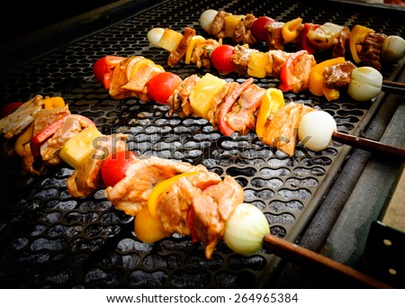 Bar-B-Q or BBQ with kebab cooking. Coal grill of pork skewers with tomatoes, onion and peppers. barbecue camping dinner.