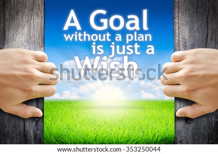 A goal without a plan is just a wish. Hand opening an old wooden door and found wording A goal without a plan is just a wish\
