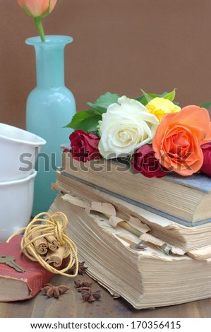 vintage composition with a old books, roses, cups and cinnamon