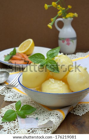 cooked potato in a ball with a crushed garlic and fresh basil, with a smoked salmon at the background
