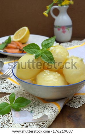 cooked potato in a ball with a crushed garlic and fresh basil, with a smoked salmon at the background