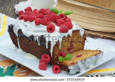 raspberry banana cake with cup of tea and old books in a background