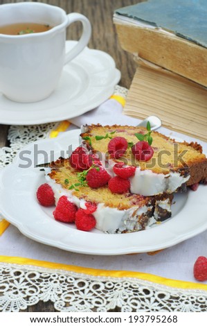 raspberry banana cake with cup of tea and old books on a background