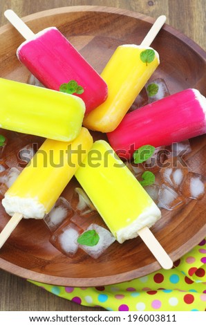 berry, lime and orange ice-creams with ice cubes and mint leaves