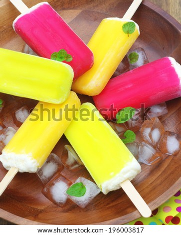 berry, lime and orange ice-creams with ice cubes and mint leaves