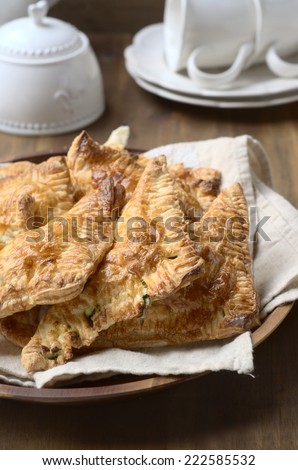 Spinach and ricotta pasties on a bamboo plate and on a wooden background