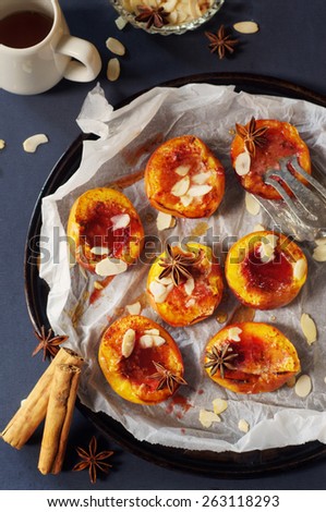 baked peaches with a cinnamon, anise, maple syrup and almond flakes. selective focus
