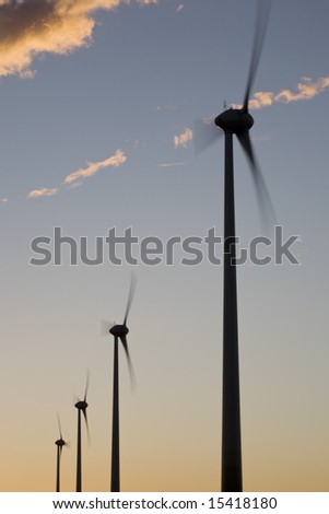 Silhouettes of wind turbines on sunset sky background (Horizontal Axis Wind Turbine HAWT)