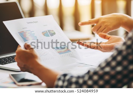 Two business woman investment consultant analyzing company annual financial report balance sheet statement working with documents graphs. Concept picture of business, market, office, tax.