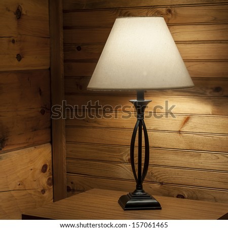 Table lamp on in cedar paneled cabin