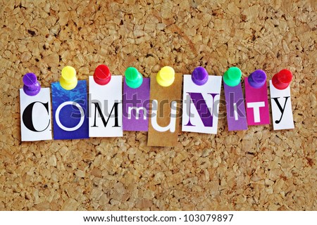 Community concept letters attached to a cork noticeboard with thumbtacks