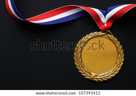 Gold medal on black with blank face for text, concept for winning or success