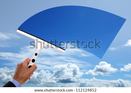 Window cleaner using a squeegee to clear the blue sky above