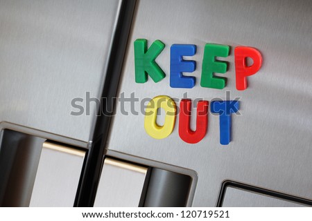 Dieting concept the words keep out spelled in fridge magnet letters on a refrigerator door