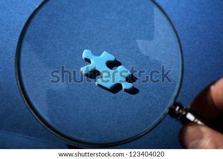 Solution concept magnifying glass finding the missing piece to the puzzle
