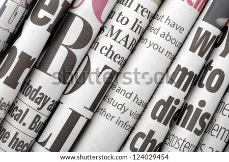 Newspaper Headlines Shown Side On In A Stack Of Daily Newspapers