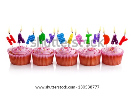Happy birthday candles on pink cupcakes isolated on white