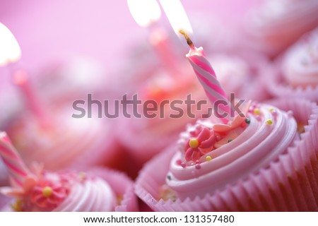 Birthday pink cupcakes with burning candles