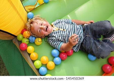 2 Year Old Boy Smiling On An Inflatable Bouncy Castle