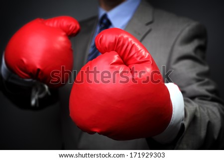 Tough competitive business concept businessman wearing boxing gloves