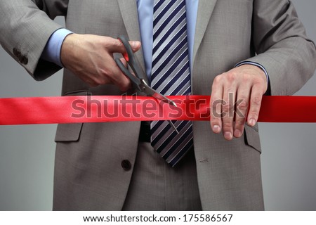 Cutting a red ribbon with scissors concept for new business venture or opening ceremony Cutting a red ribbon with scissors concept for new business venture or opening ceremony