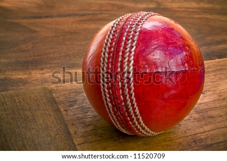Close up of cricket ball on wooden bat
