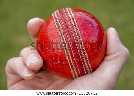 Cricket bowlers hand with ball about to bowl