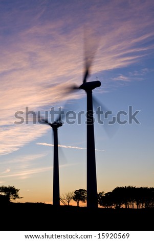 Silhouette of wind turbines against a sunset