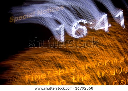 Airport departure board with digital clock and blurred motion