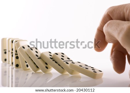 Line of dominos falling down after being pushed by finger
