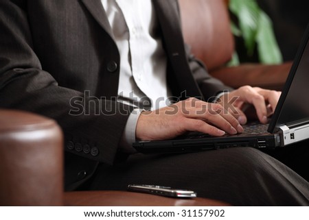 Relaxed businessman working on a laptop sitting on a sofa