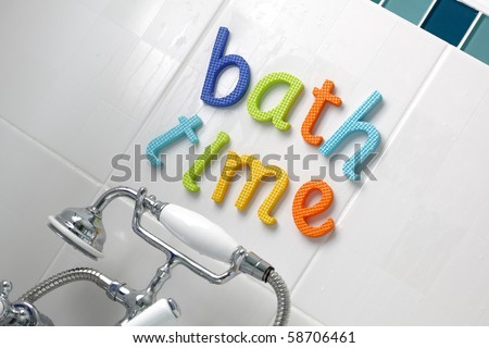 Foam letter sign reading bath time above a mixer tap with shower attachment