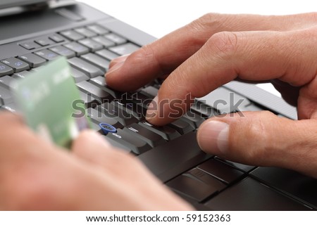 Person with a credit card using a computer for internet shopping