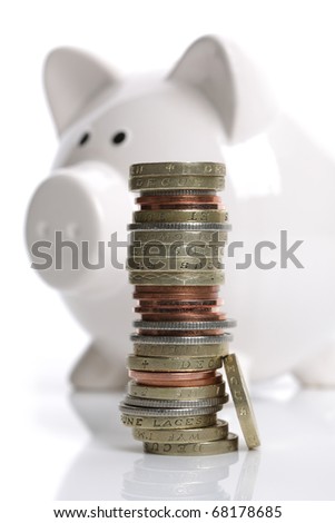 Savings stacked in front of a white piggy bank