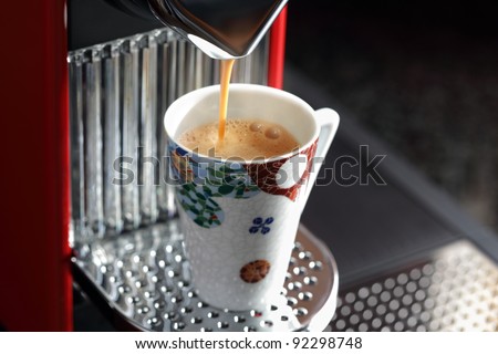 Fresh espresso coffee pouring into a cup from coffee maker