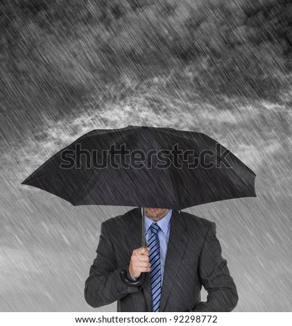 Businessman with umbrella protecting himself from the storm concept for protection from recession or economic depression etc