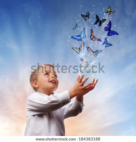 Boy releasing butterflies into the air concept for freedom, peace and spirituality