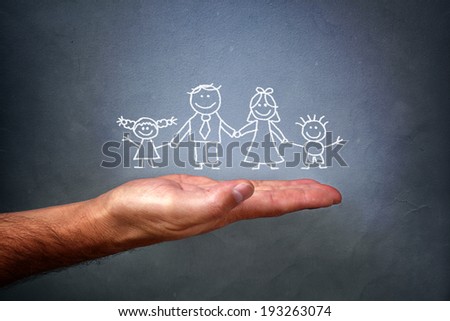 Children\'s chalk drawing on a blackboard of a happy family with mom, dad, son and daughter holding hands being held in the palm of a mans hand