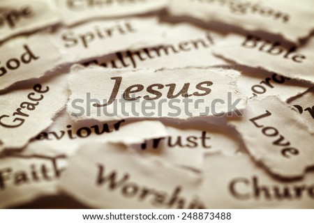 Torn paper words of religion with focus on word Jesus