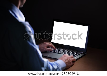 Late night internet addiction or working late man using laptop at a desk in the dark