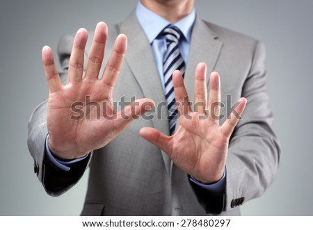 Stop or fear gesture from businessman in suit holding hands up
