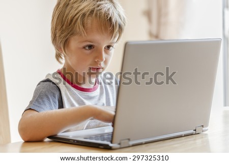 Young boy working on laptop computer concept for education, learning, internet, homework and social media