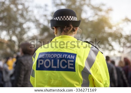 Police officer in hi-visibility jacket policing crowd control at a UK event